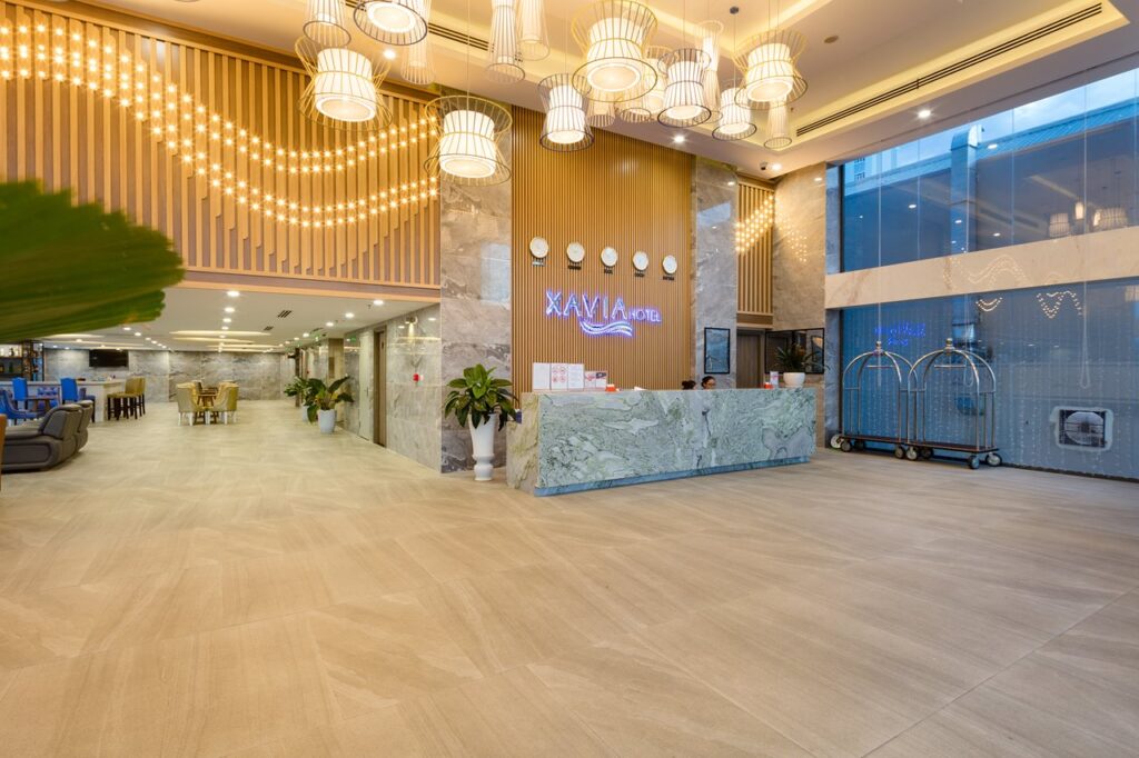 Sảnh lễ tân Xavia Hotel với nội thất gỗ hiện đại